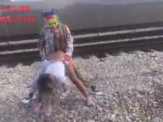 Badut mengongkek gadis sekolah pada keretapi tracks